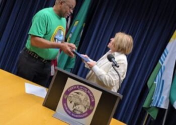 President, Nigerian American Association of the Inland Northwest (NAAINW), Damien Unogu (left), receiving a copy of the Proclamation of Nigerian American week from the Mayor of Spokane, Washington State, Lisa Brown.